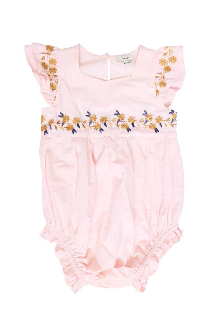 Introducing the Baby Hattie Romper in Embroidered Spring Floral by Ivy City Co—this light pink cotton romper features soft, slightly crinkled fabric for ultimate comfort. Delicate ruffled sleeves and charming yellow and purple spring floral embroidery adorn the chest and upper bodice, making it a stylish choice for your little one.