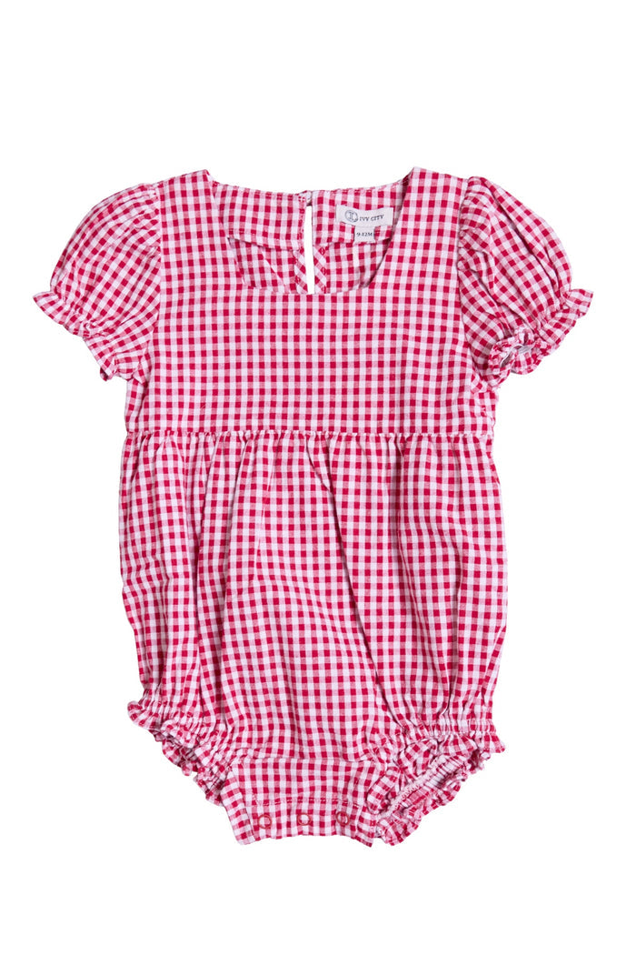 The Ivy City Co Baby Jessie Romper in Red Gingham features short puffed sleeves, ruffled edges, and a gathered waist—an adorable Fourth of July outfit for your little one. Displayed flat on a white background.