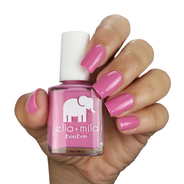 Beet Goes On deep bubblegum pink nail polish on a deep skin tone, hand holding the bottle