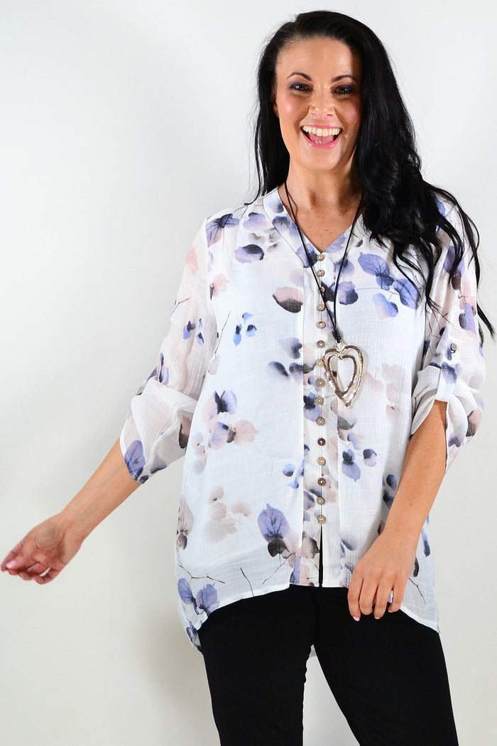 Blue floral botanical tunic top by Caroline Morgan, featuring a relaxed fit and vibrant flower print, displayed on a hanger.