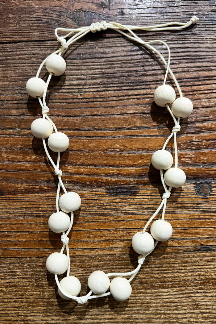 Boho cream-colored wooden bead necklace with adjustable design, featuring round beads, stylish accessory for casual outfits.