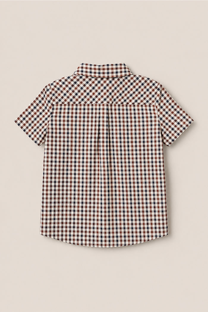 Short-sleeved button-up cotton shirt with a collar, shown from the back. The Boys James Shirt in Chestnut Gingham by Ivy City Co features a chestnut brown, white, and blue checkered pattern with a central pleat below the yoke.