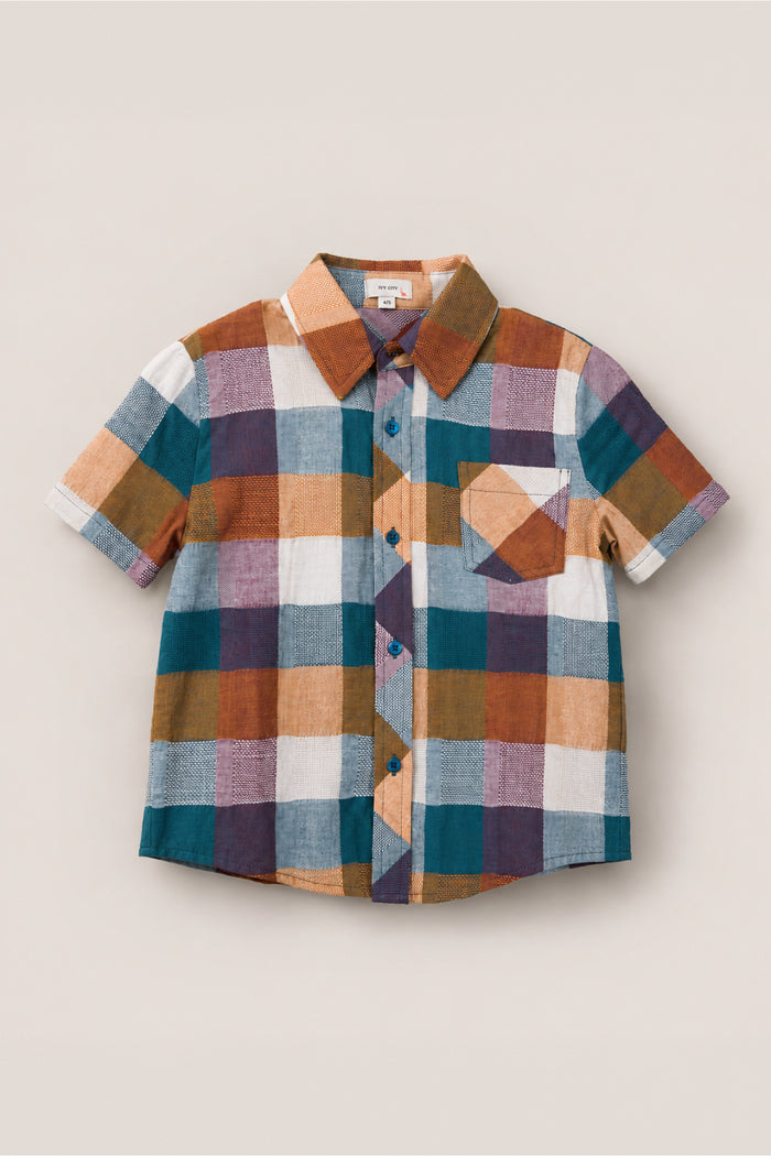 Introducing the Boys James Shirt in Maize Gingham from Ivy City Co—a short-sleeve button-up designed with a bold checkered pattern in blue, brown, yellow, white, and purple hues. Made from a soft cotton-blend fabric for all-day comfort, this shirt also features a matching checkered chest pocket.