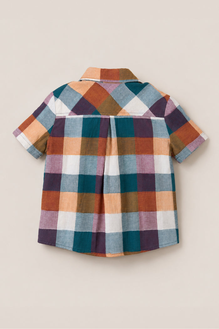 The Boys James Shirt in Maize Gingham by Ivy City Co is a short-sleeve button-up featuring a large plaid pattern in blue, orange, purple, and white. Made from a soft cotton-blend fabric, the shirt is displayed from the back on a beige background.