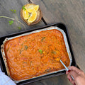 Ready-to-eat organic curry in foil tray with lemon wedges, pasture-raised ingredients, gluten-free meal