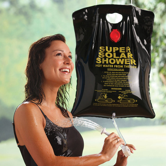Lifestyle shot of a woman using Coghlans solar heated camp shower to wash