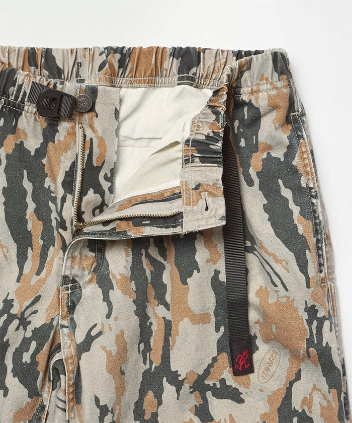Close-up view of bark camo Denim Gramicci Pant Straight Fit showing waistband and zipper detail on a light-tone background.
