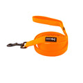 The Dog Leash - Neon Orange by Sassy Woof features a padded handle, metal clip, and black-and-white brand label. Coiled neatly against a plain white background, it’s perfect for fans of colorful dog accessories.