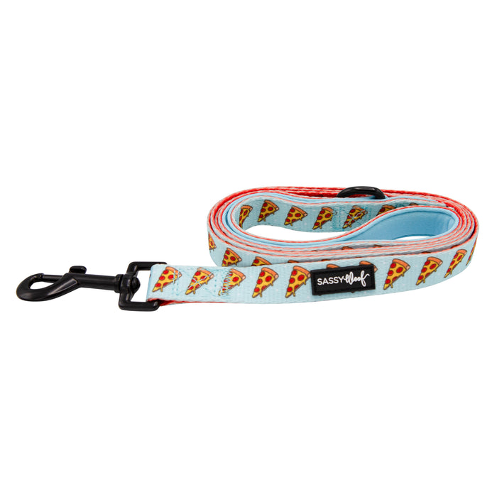 The Sassy Woof Dog Leash - One Hot Pupperoni features a rolled light blue design with pizza slices, comfy neoprene handle, black metal clasp, and "Sassy Woof" label—perfect to pair with the matching harness set.