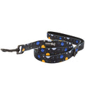 The Sassy Woof "To the Stars and Beyond" dog leash features a space-inspired design with blue, yellow, and white planets and stars, plus a sleek black metal clasp—celebrating girls in STEM and computer science.
