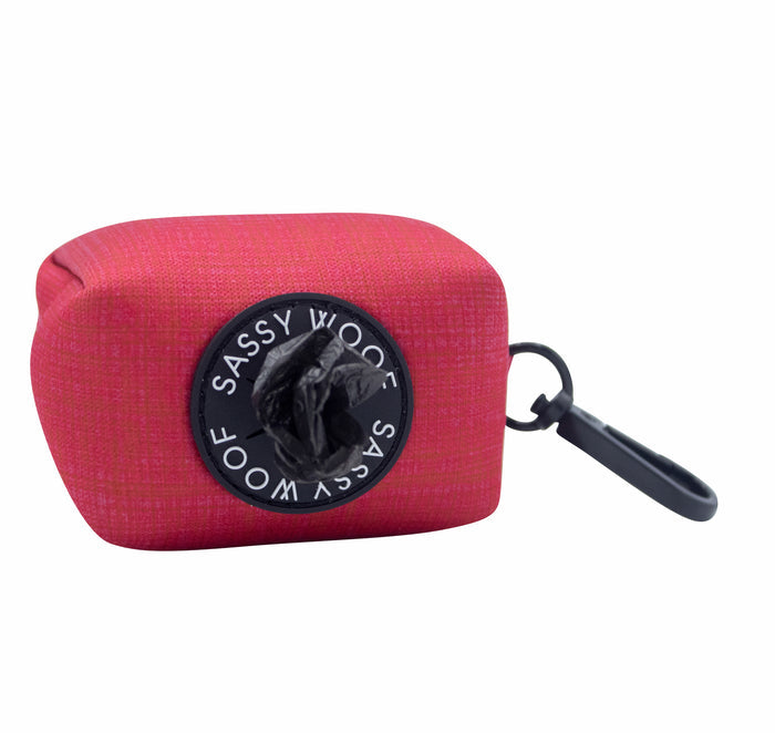 The Sassy Woof Dog Waste Bag Holder - Merlot is a stylish red neoprene accessory with a black circle, ideal for daily dog walks.