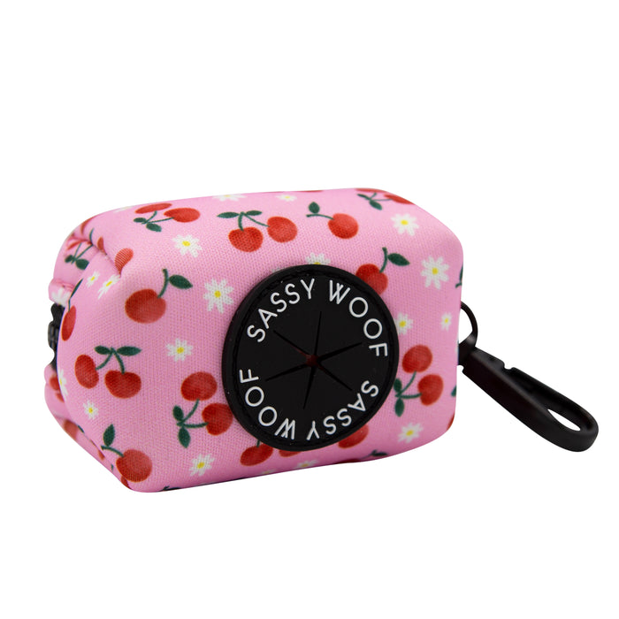 The Sassy Woof Dog Waste Bag Holder - Mon Chérry features a charming cherry pattern in pink, adding stylish flair to carrying your dog’s waste bags.