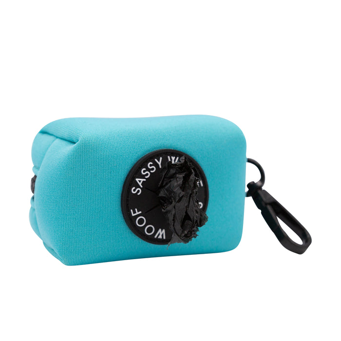 The Sassy Woof Dog Waste Bag Holder - Neon Blue features neoprene material, a black clip, a round opening with "Sassy Woof" printed around it, and pairs perfectly with matching harnesses and other neon accessories.
