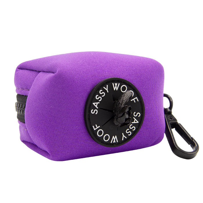 The Sassy Woof Dog Waste Bag Holder - Neon Purple is a compact, rectangular neoprene pouch with a black zipper, circular logo, and black clip—ideal for pairing with colorful dog accessories.
