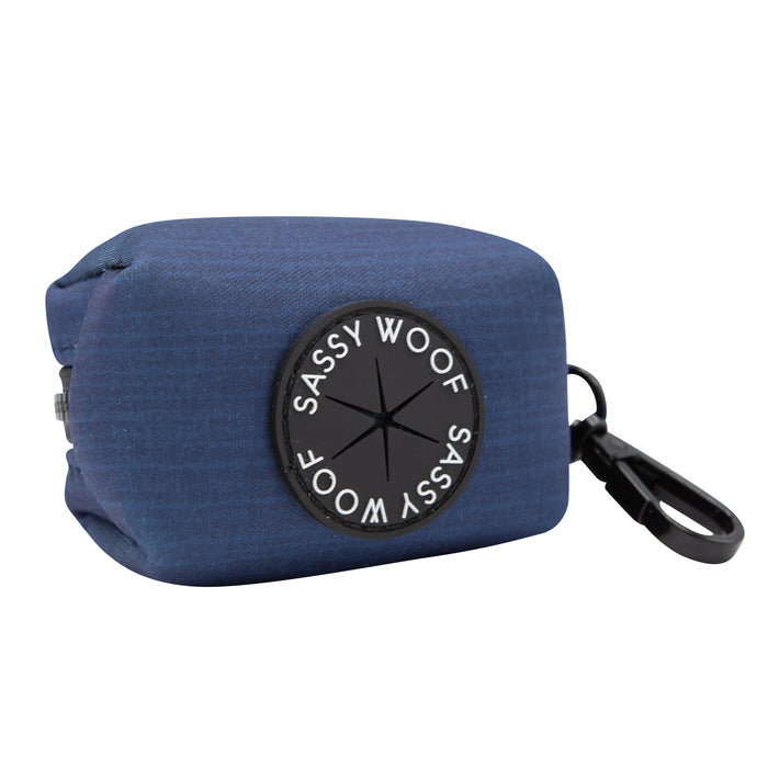 The Sassy Woof Dog Waste Bag Holder - Twilight is a blue neoprene holder with a black circular logo and clip, designed to attach easily to your harness for convenient bag dispensing.
