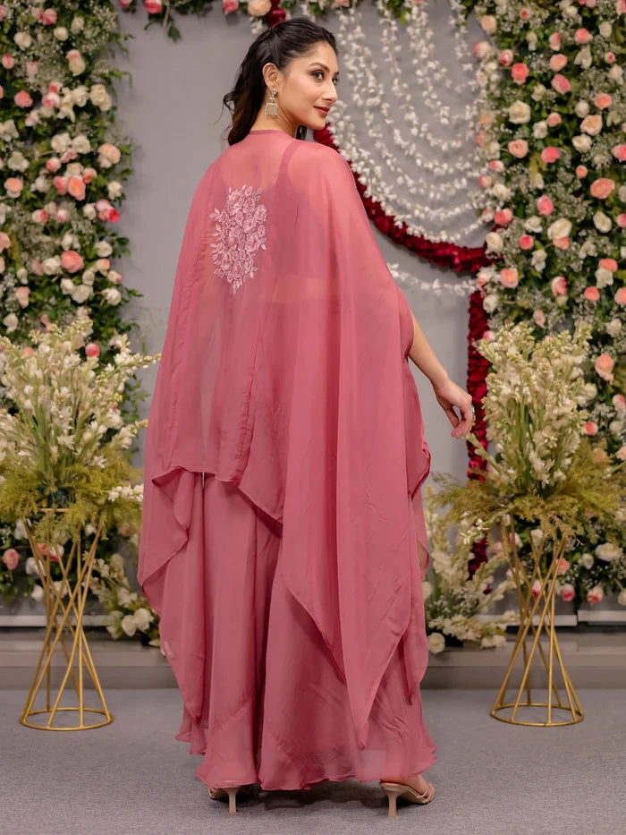 Woman in a pink dress with floral decorations in the background