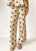 Beige outfit with brown polka dots on a plain background