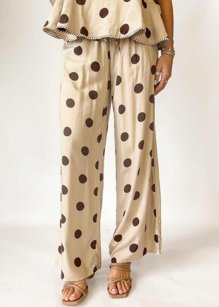 Beige outfit with brown polka dots on a plain background