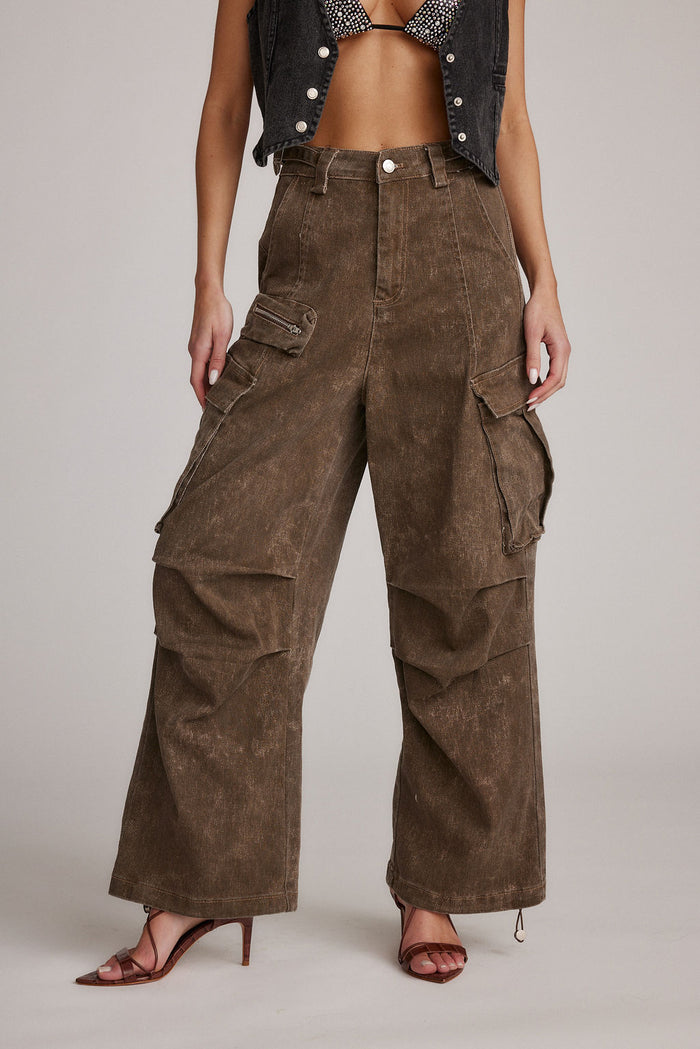 Fleetwood brown cargo pants worn high-waisted and wide-leg with denim vest and heeled sandals.