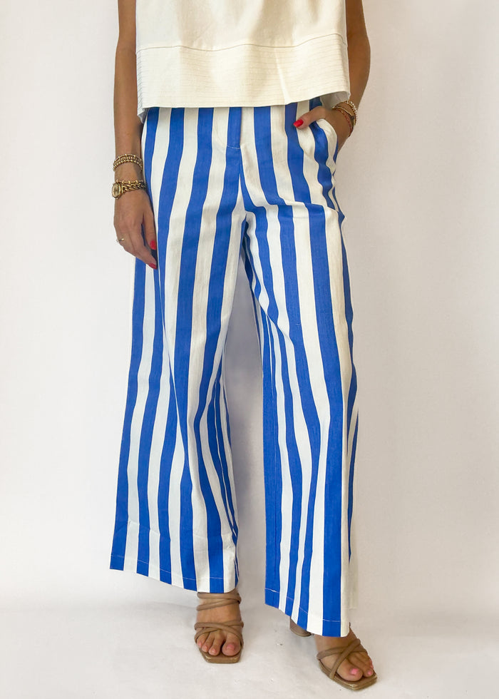 Person wearing blue and white striped pants on a plain background