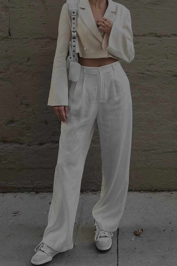 High waisted white wide leg trousers styled with a cropped blazer and sneakers.
