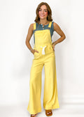Woman wearing yellow overalls on a white background