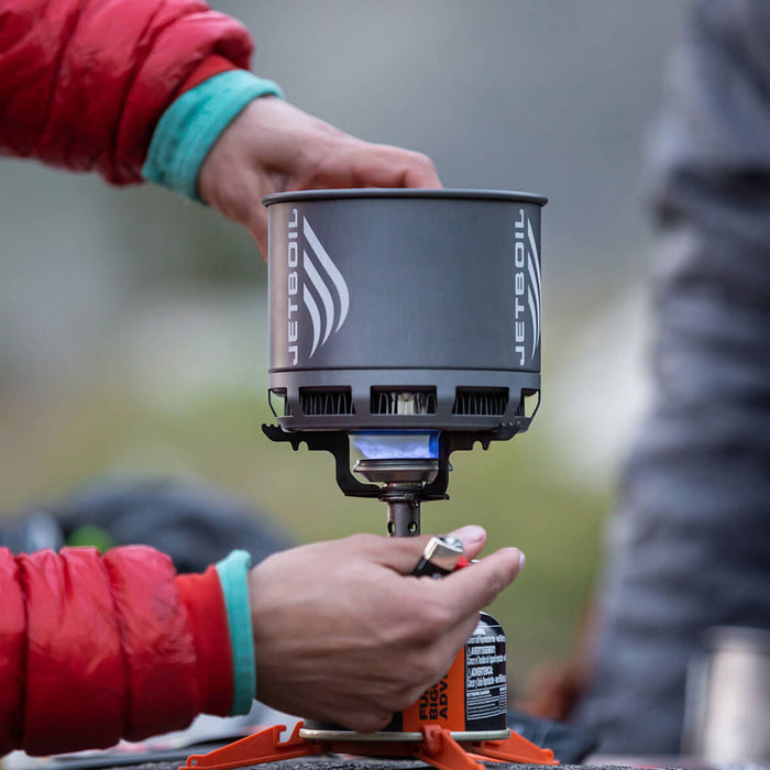 Lifstyle image of a man outdoors lighting a Jetboil Stash gas stove