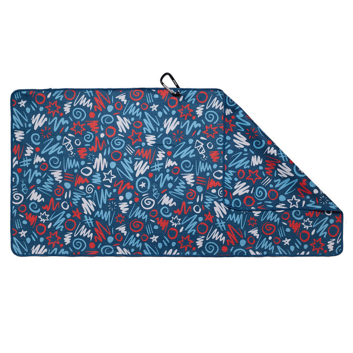 A rectangular blue picnic blanket with a folded corner, featuring a pattern of red, white, and blue doodles including stars, squiggles, and spirals. A black carrying handle is attached near the folded corner.