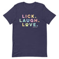 The Lick, Laugh, Love Tee by Sassy Woof is a navy unisex pet shirt featuring “LICK. LAUGH. LOVE.” in pastel colors with a paw print "O" and the Sassy Woof logo below—lightweight and perfect for dog lovers.