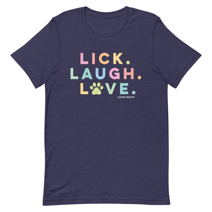 The Lick, Laugh, Love Tee by Sassy Woof is a navy unisex pet shirt featuring “LICK. LAUGH. LOVE.” in pastel colors with a paw print "O" and the Sassy Woof logo below—lightweight and perfect for dog lovers.
