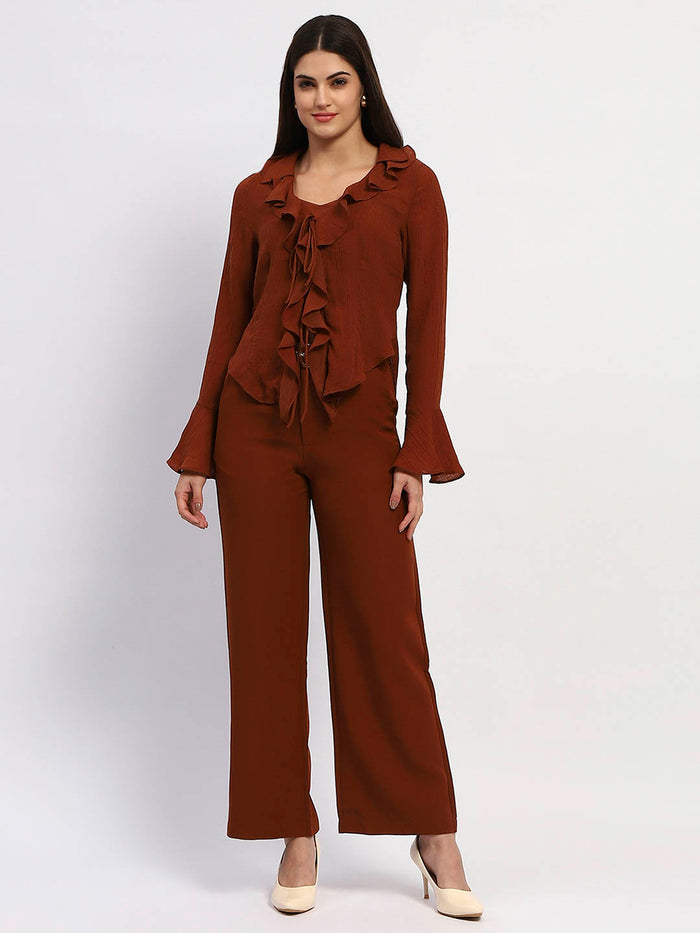 Woman wearing a brown outfit with ruffled top and wide-leg pants on a white background