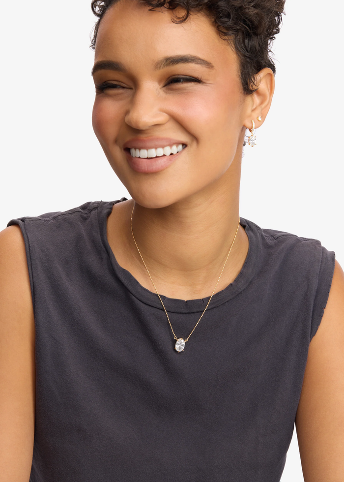 Woman wearing a gold simulated diamond pendant necklace