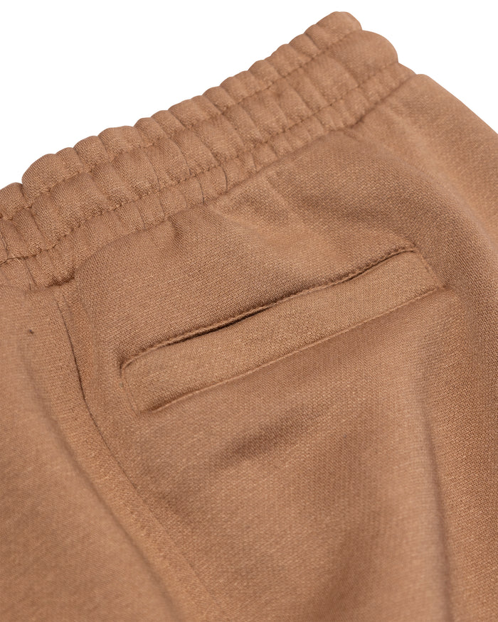 Close-up of brown pants with a pocket on a white background