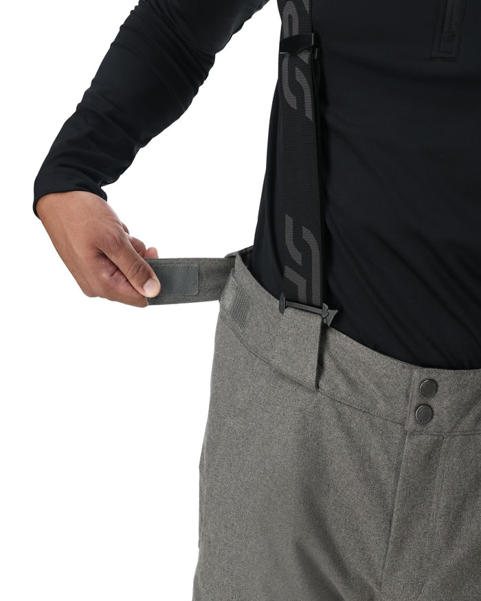 Person wearing gray pants with a black belt and black shirt on a white background