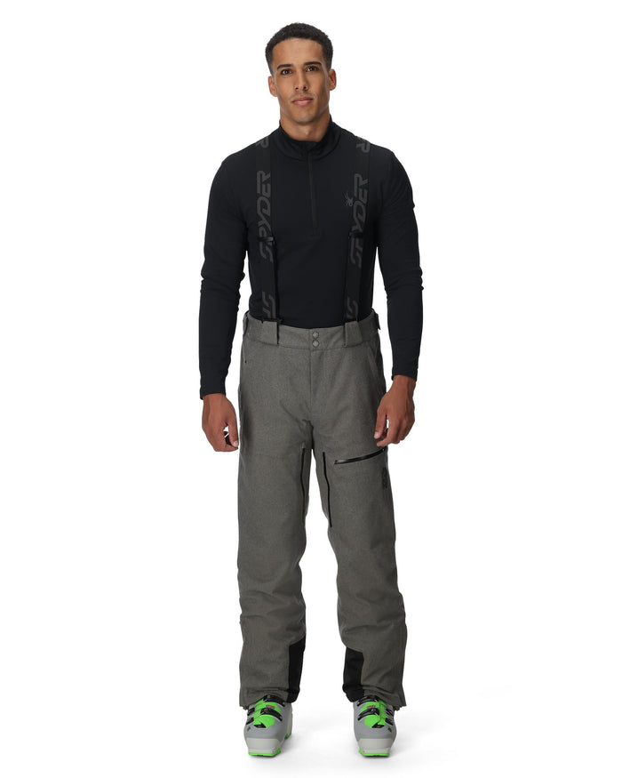 Man wearing a black jacket and gray pants on a white background