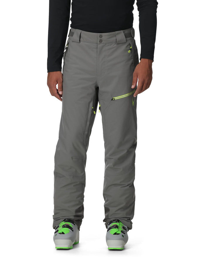 Gray pants with green accents worn by a person on a white background