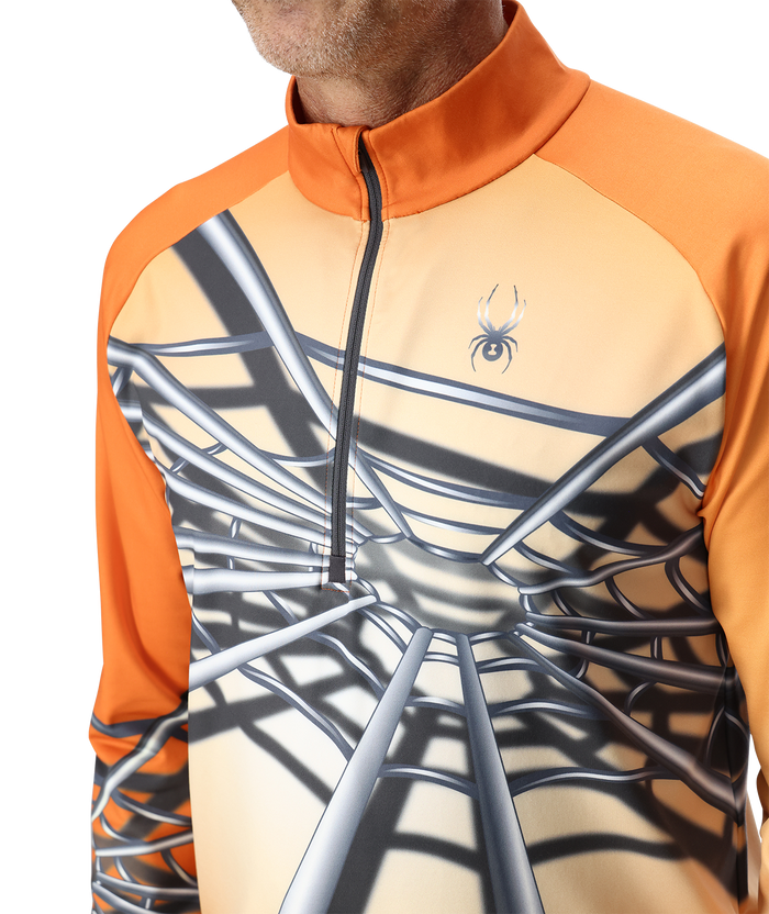 Orange and beige long-sleeve shirt with spider web design and logo on a white background