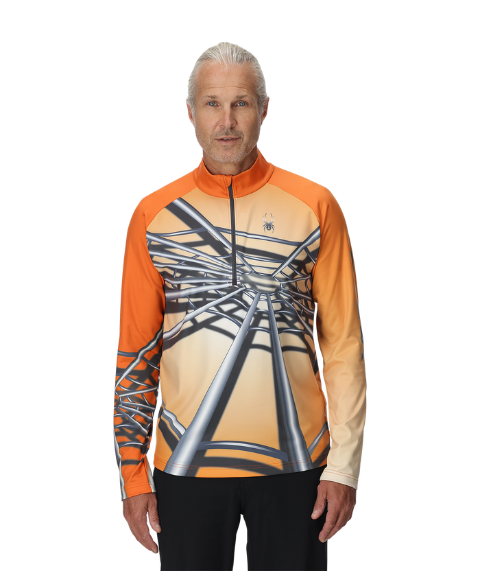 Man wearing an orange and beige long-sleeve shirt with a unique design on a white background