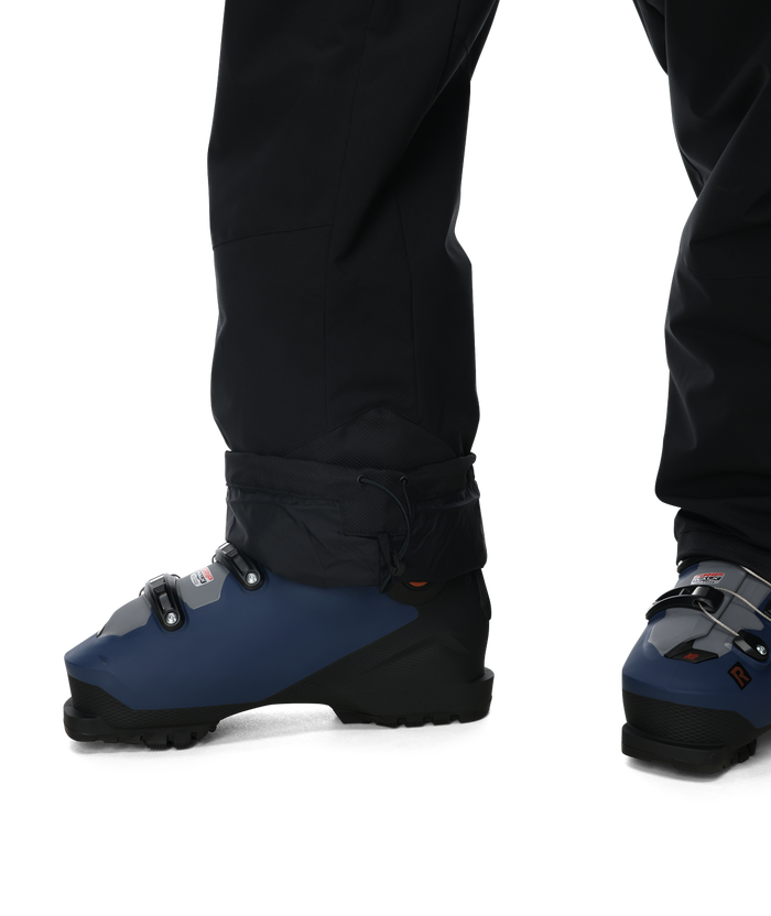 Blue ski boots with black gaiters worn by a person on a white background