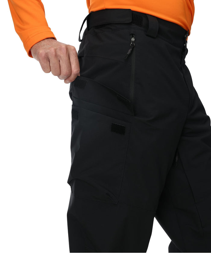 Black pants worn by a person with an orange shirt on a white background