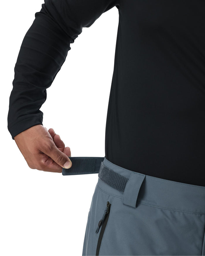 Person wearing a black long-sleeve shirt and gray pants with a white background