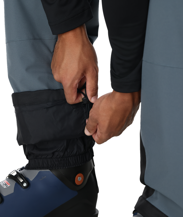 Person adjusting a blue and black boot with a white background