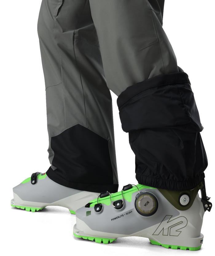 Close-up of ski boots with K2 branding and gaiters on a white background