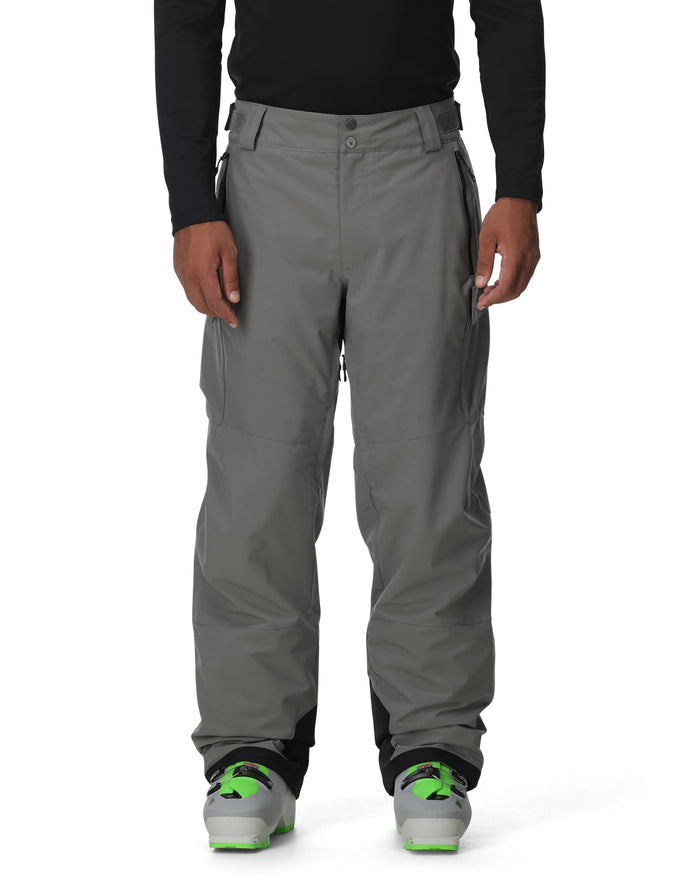 Person wearing gray pants with a black top on a white background