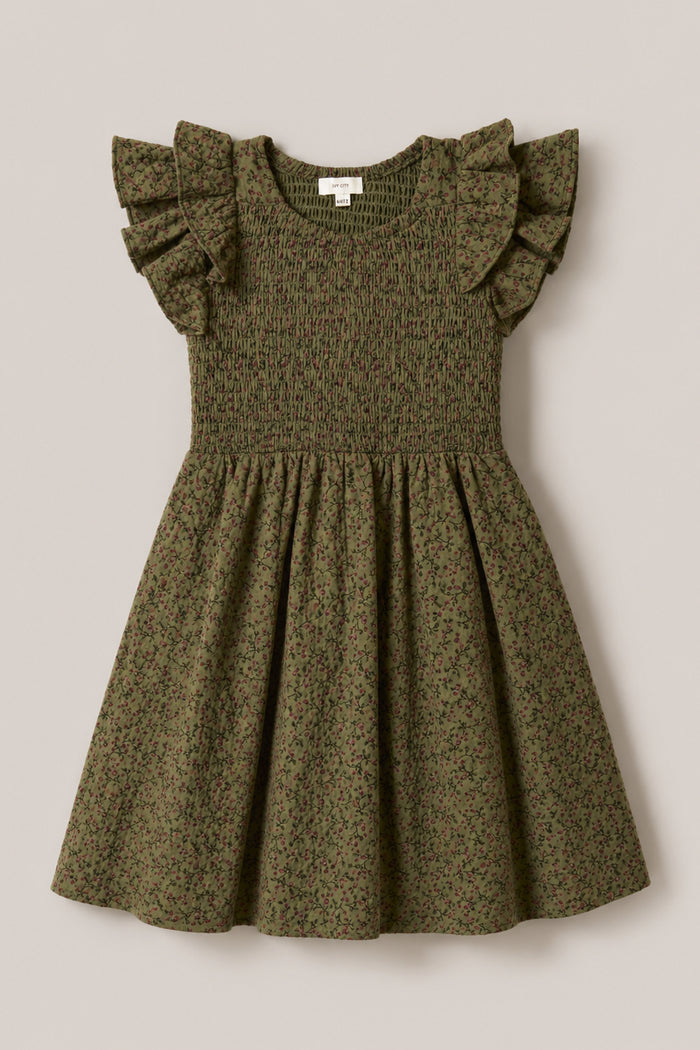The Mini Hattie Dress in Woodland Floral by Ivy City Co features a smocked bodice, ruffled cap sleeves, and a flared skirt, all crafted from soft cotton. Adorned with a subtle small floral print, this charming dress is displayed flat on a plain beige background.