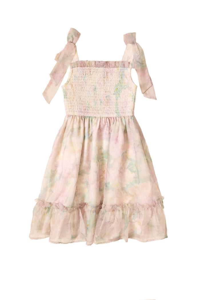 The Mini Rhiannon Dress in Painted Bloom by Ivy City Co is a sleeveless organza girls dress with a smocked bodice, shoulder tie straps, and a ruffled hem, featuring a pink, green, and yellow watercolor floral pattern—perfect for special occasions.