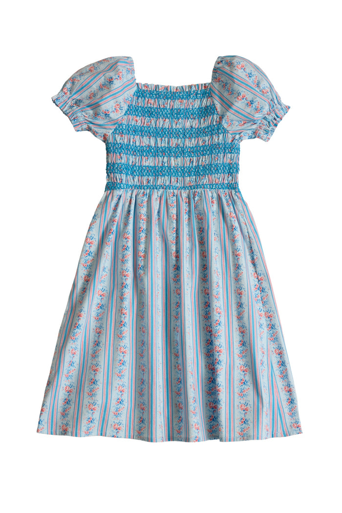 The Mini Sunday Best Dress in Rosette Linear Stripe by Ivy City Co features a light blue hue, puffed sleeves, shirred bodice, and a floral striped skirt in pink, white, and blue. Perfect for Mom and Me matching moments.