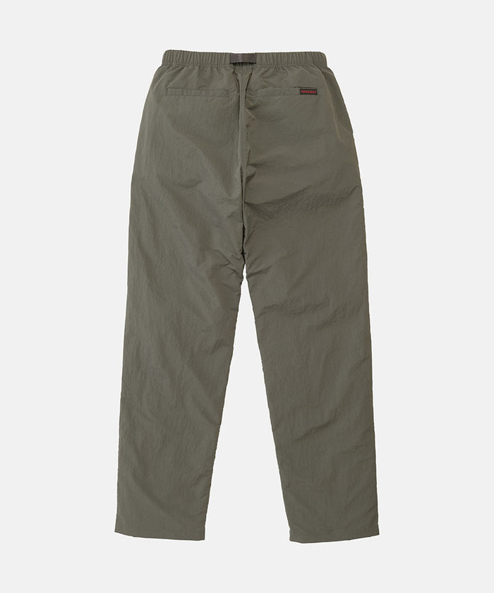 Back view of burnt olive colored Nylon Gramicci Pants on a light-tone background.