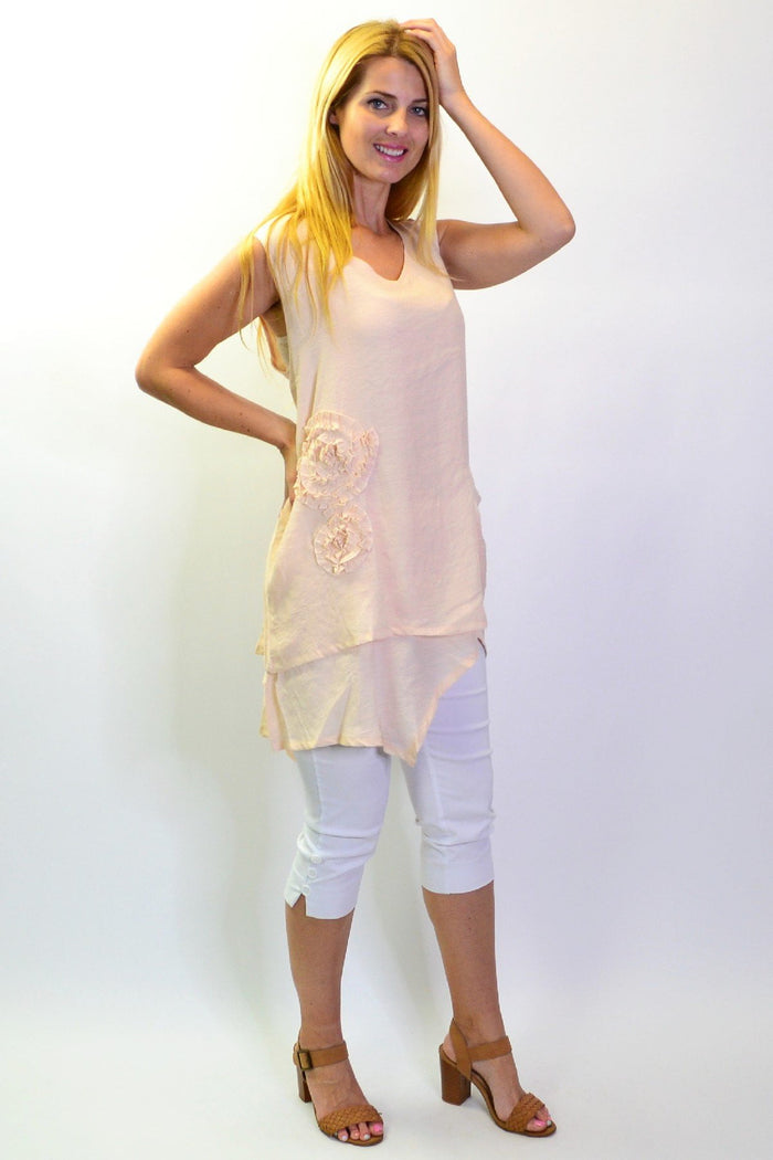 Peach sleeveless tunic top with appliqué details from La Mode, shown hanging on a hanger with a plain background.