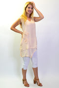 Peach sleeveless tunic top with appliqué details from La Mode, shown hanging on a hanger with a plain background.